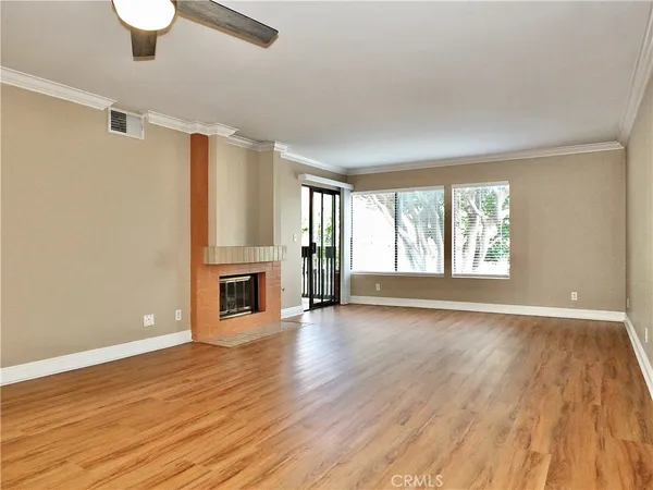 wooden floor fireplace and windows in an empty room