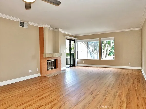 wooden floor fireplace and windows in an empty room