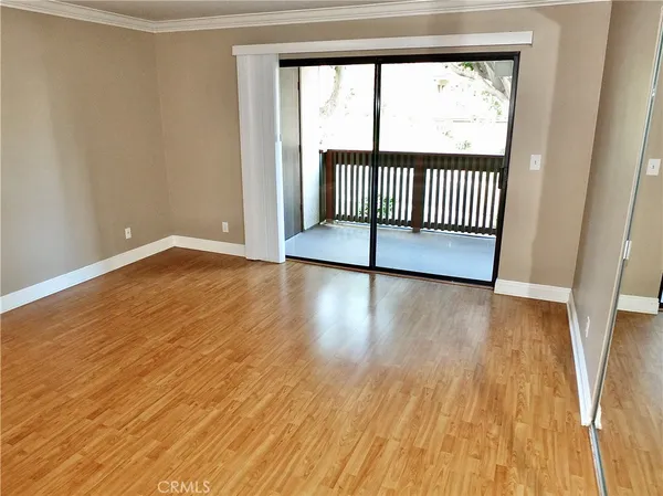 a view of a room with wooden floor and a window