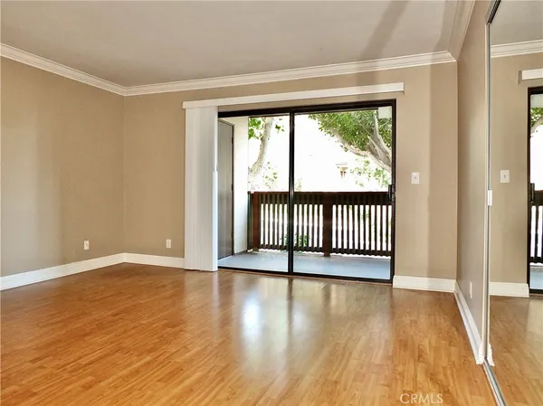 a view of a room with wooden floor and a window