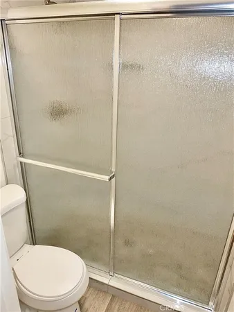 a white toilet sitting next to a shower