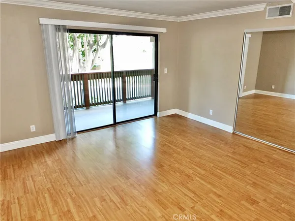 a view of a room with wooden floor and a window