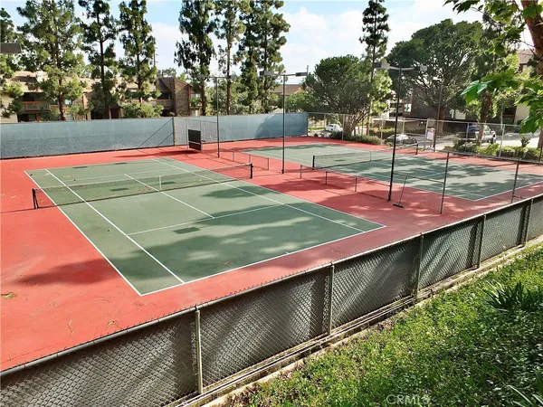 a view of a tennis ground with large trees