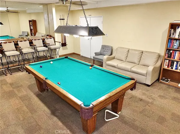 a room with furniture pool table and windows