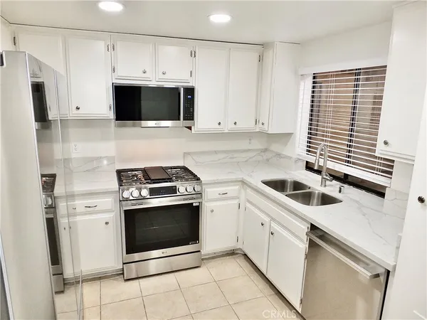 a kitchen with white cabinets and stainless steel appliances