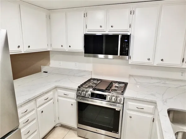a kitchen with white cabinets and stainless steel appliances