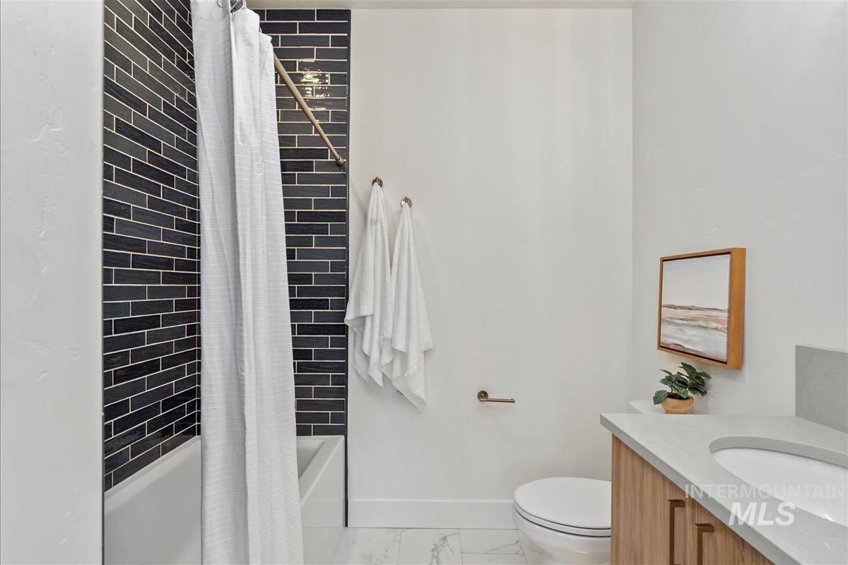 3255 West Moore Street Boise, ID 83702 - Photo 33 of 44 Bathroom with shower / bathtub combination with curtain, vanity, and light marble finish flooring