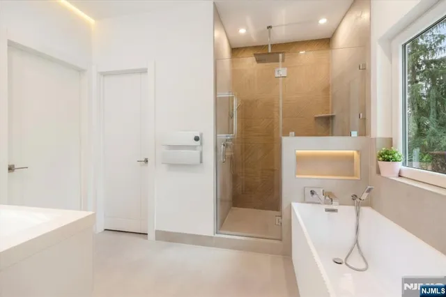 a bathroom with a tub shower and sink