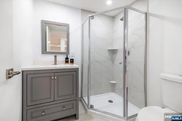a bathroom with a shower sink vanity and mirror