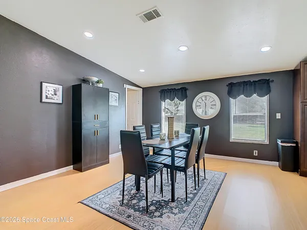 a view of a dining room with furniture and a chandelier