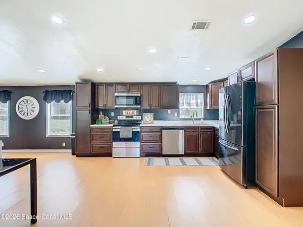 a kitchen with stainless steel appliances granite countertop a refrigerator a stove top oven a sink and dishwasher