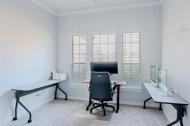 a view of a workspace with furniture and a window