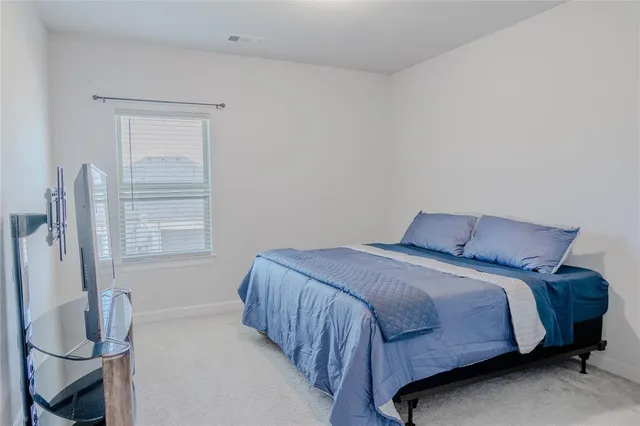 a bed sitting in a bedroom next to a window