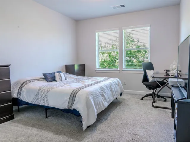 a bedroom with a bed chair and a window