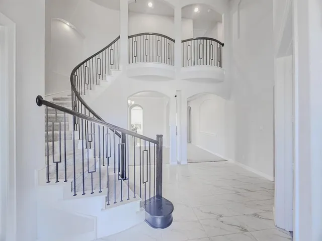 a view of staircase with white walls and railing