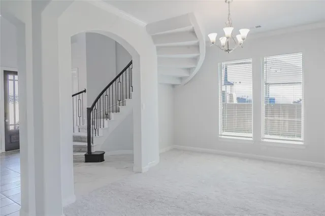 a view of empty room with chandelier