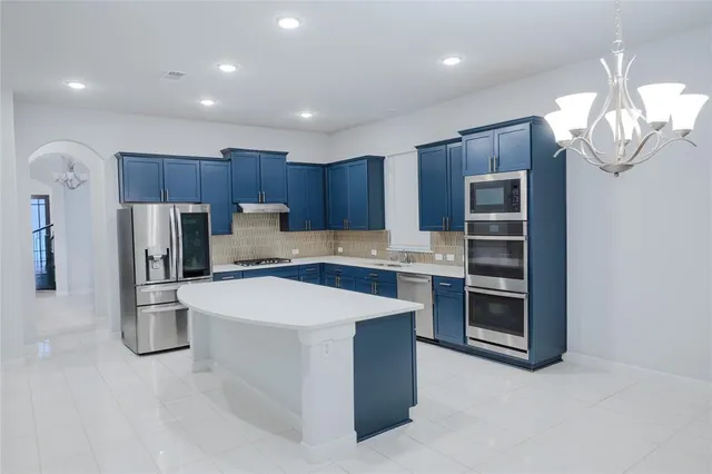 a kitchen with stainless steel appliances a refrigerator sink and cabinets