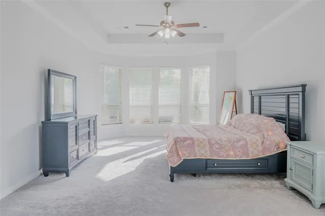 a spacious bedroom with a bed and a chandelier