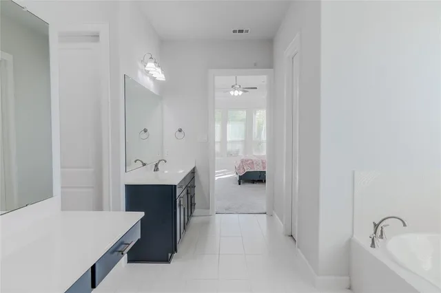 a large bathroom with a sink a mirror and a bathtub
