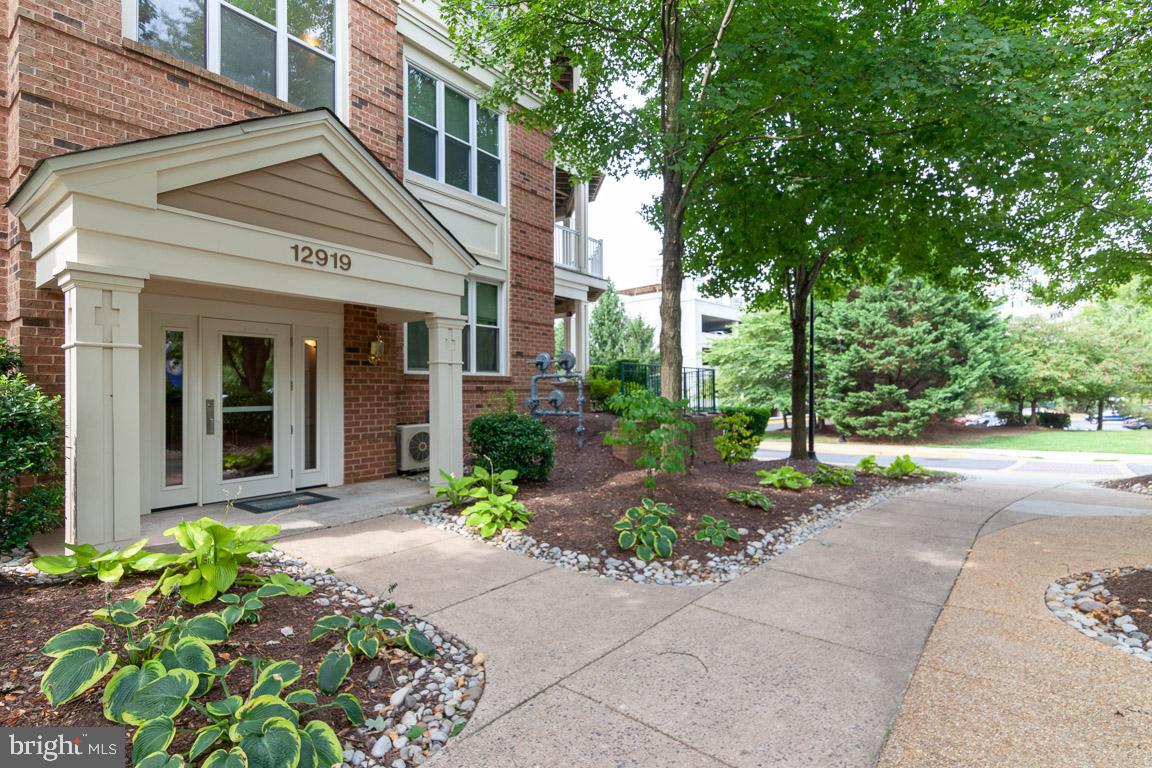 a front view of a house with garden and plants