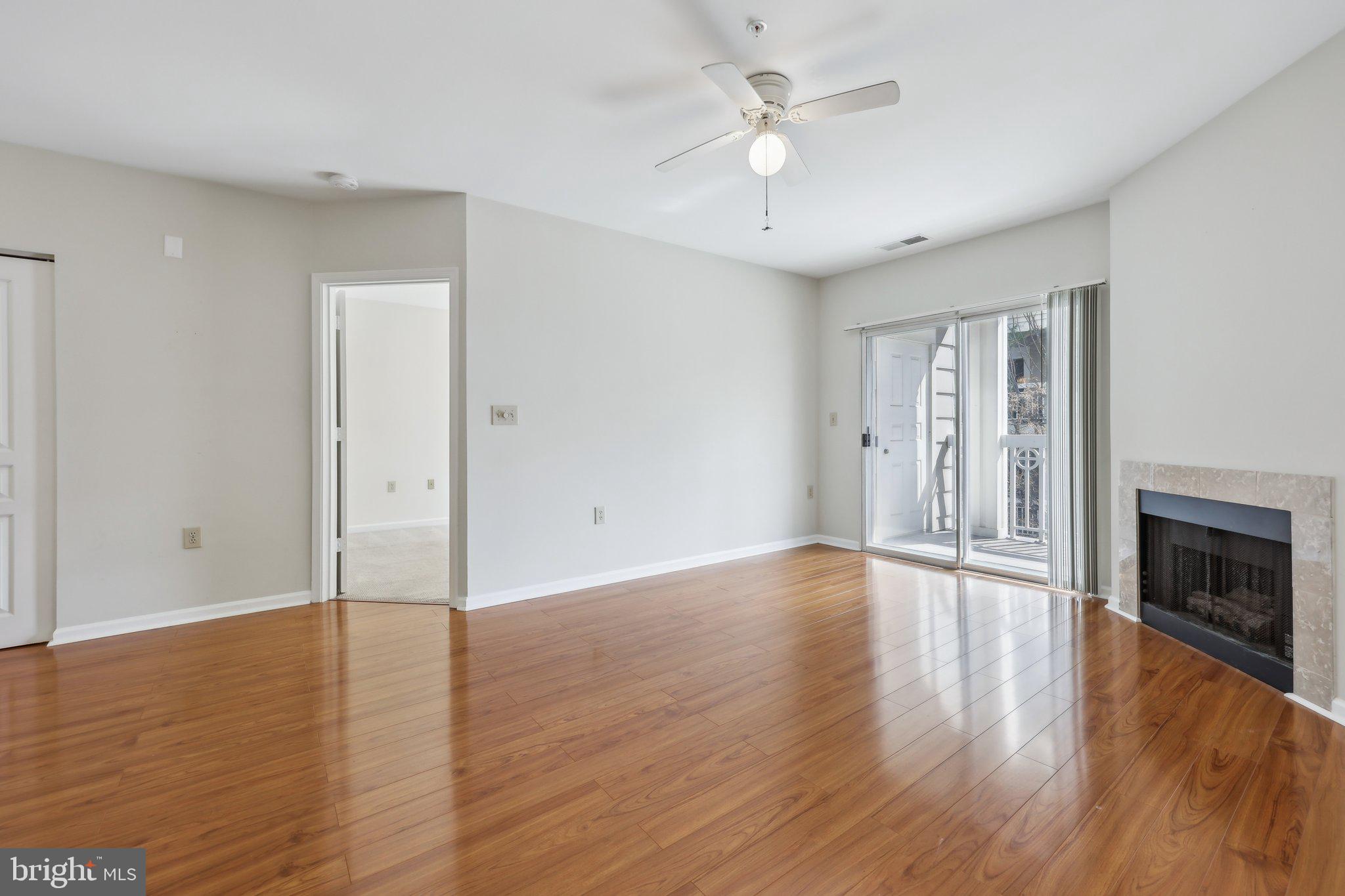12919 Alton Square, Unit 302 Herndon, VA 20170 - Photo 8 of 21 an empty room with wooden floor fireplace and windows