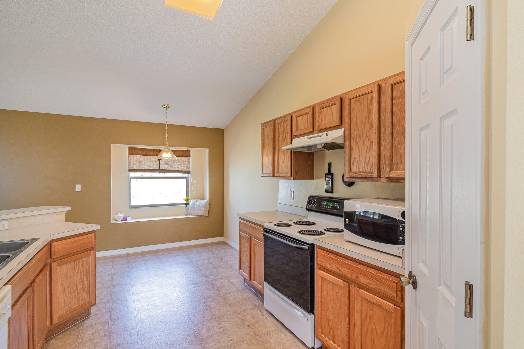 1391 Saxony Road Southwest Palm Bay, FL 32908 - Photo 11 of 28 a kitchen with stainless steel appliances a stove a sink and a refrigerator