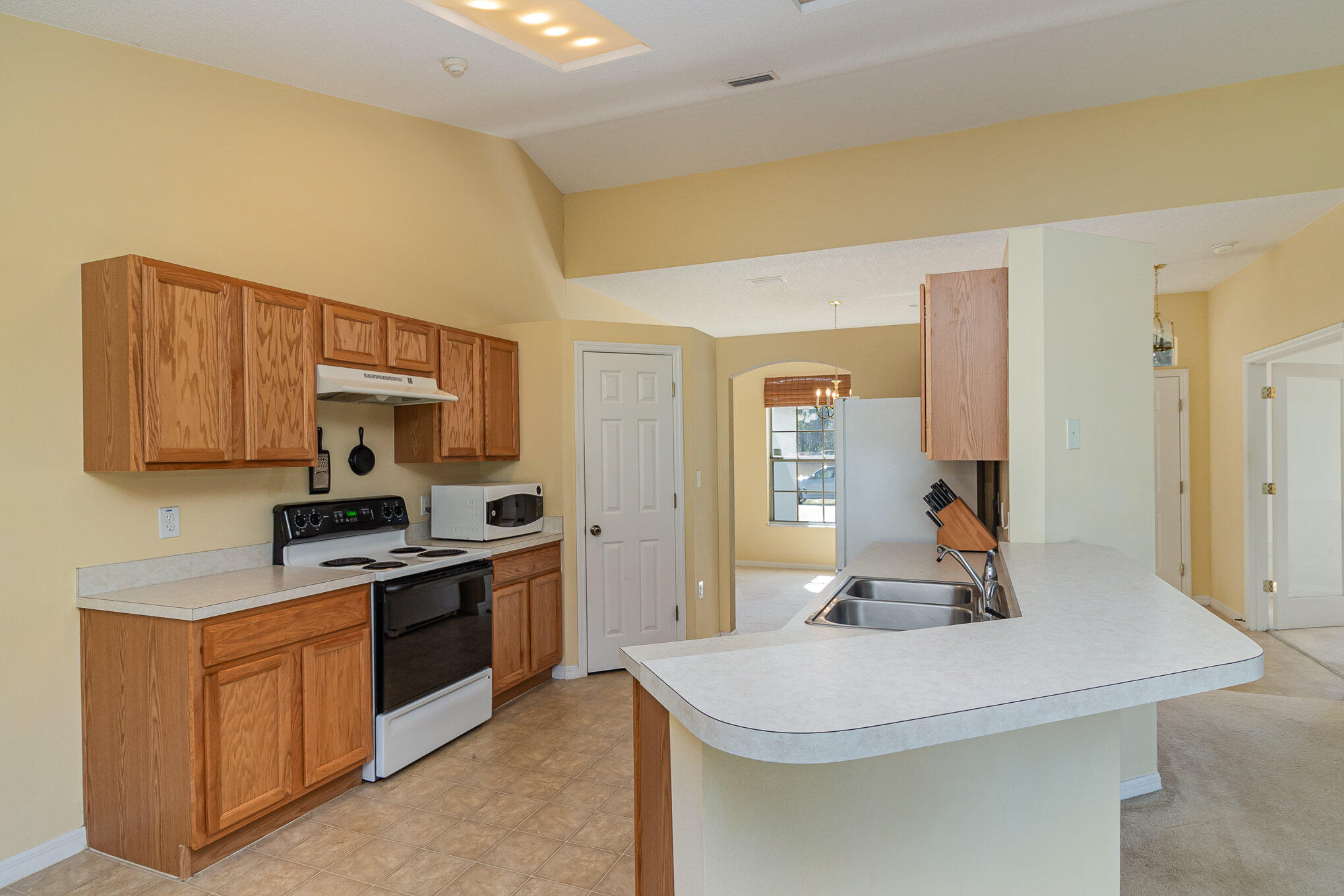 1391 Saxony Road Southwest Palm Bay, FL 32908 - Photo 12 of 28 a kitchen with stainless steel appliances a sink stove and cabinets