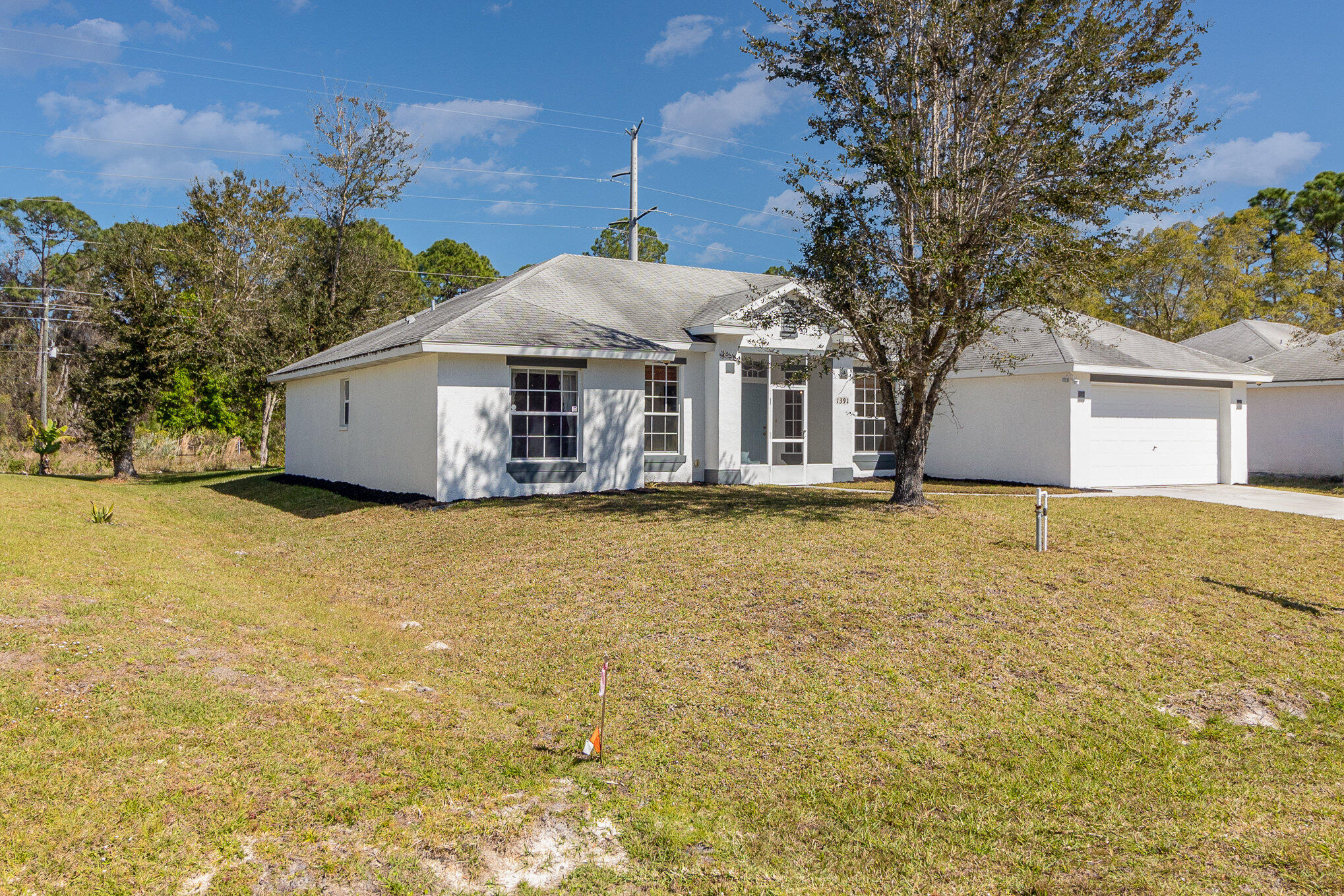 1391 Saxony Road Southwest Palm Bay, FL 32908 - Photo 2 of 28 a front view of a house with a large tree