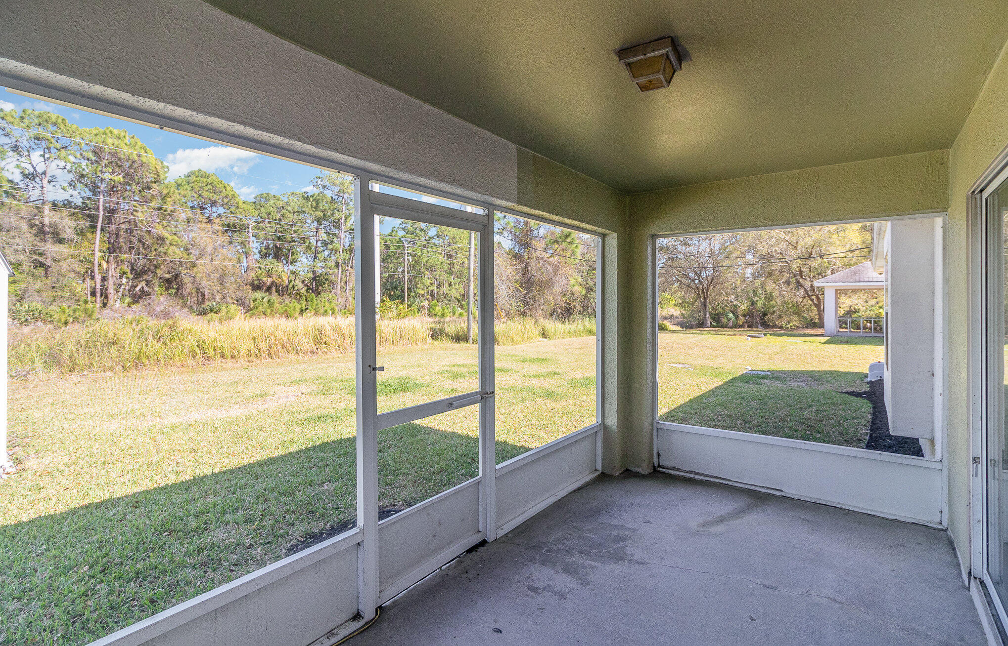 1391 Saxony Road Southwest Palm Bay, FL 32908 - Photo 23 of 28 wooden floor in an empty room with a large window
