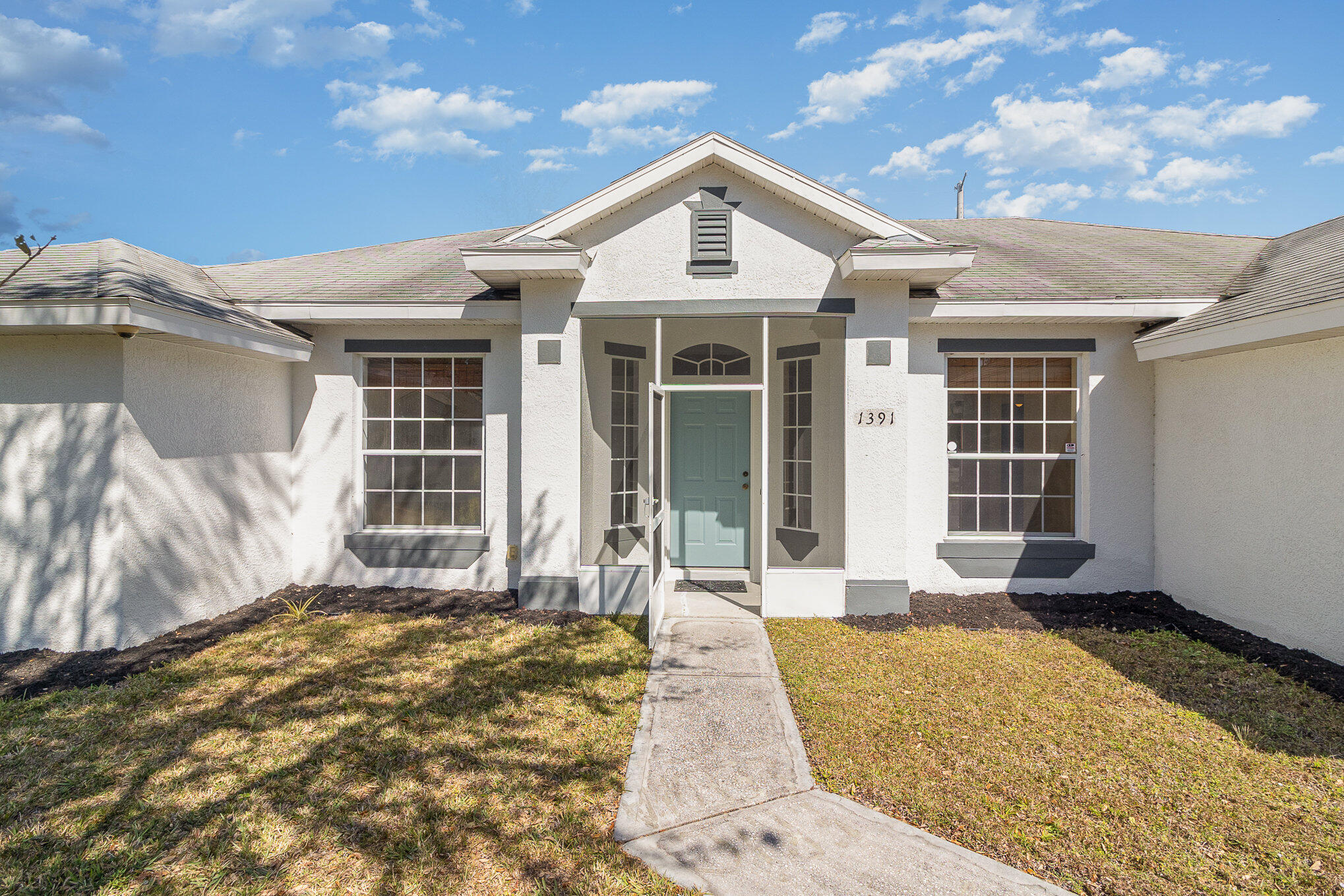 1391 Saxony Road Southwest Palm Bay, FL 32908 - Photo 5 of 28 a front view of a house with a yard