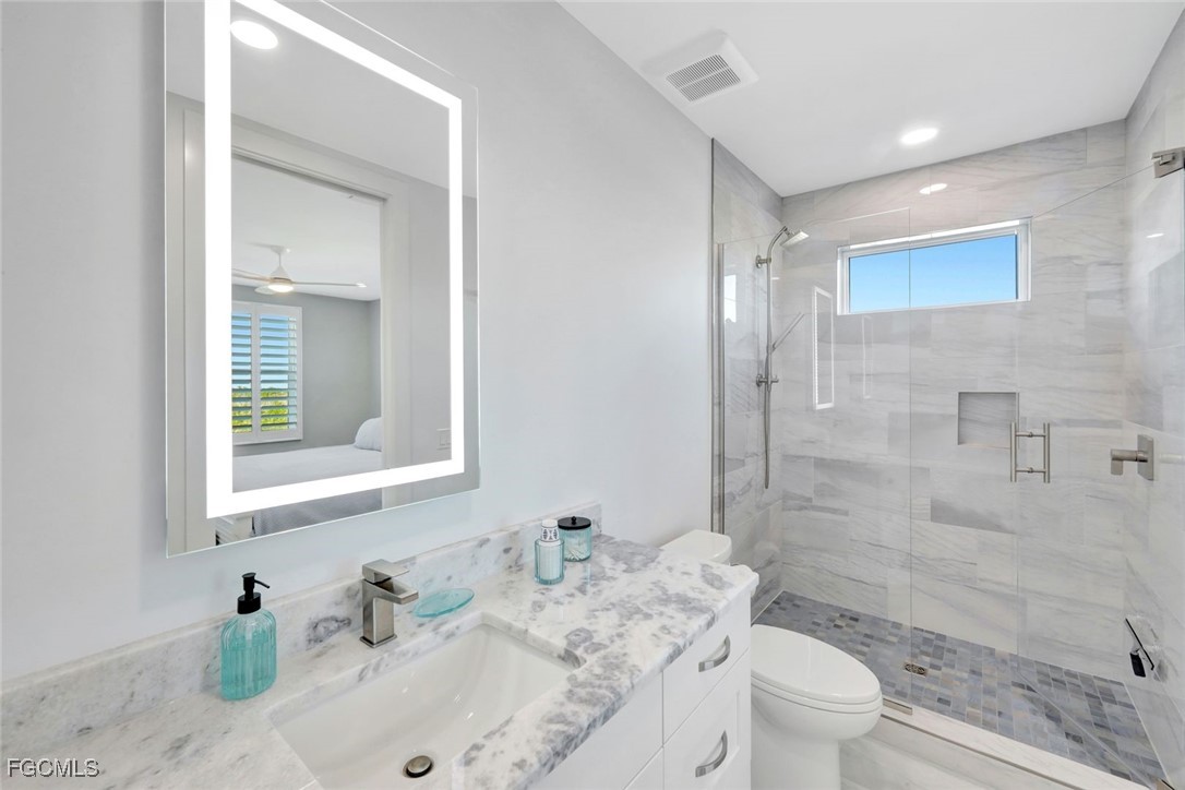 1044 Fish Crow Road Sanibel, FL 33957 - Photo 26 of 36 a bathroom with a sink toilet tub and shower