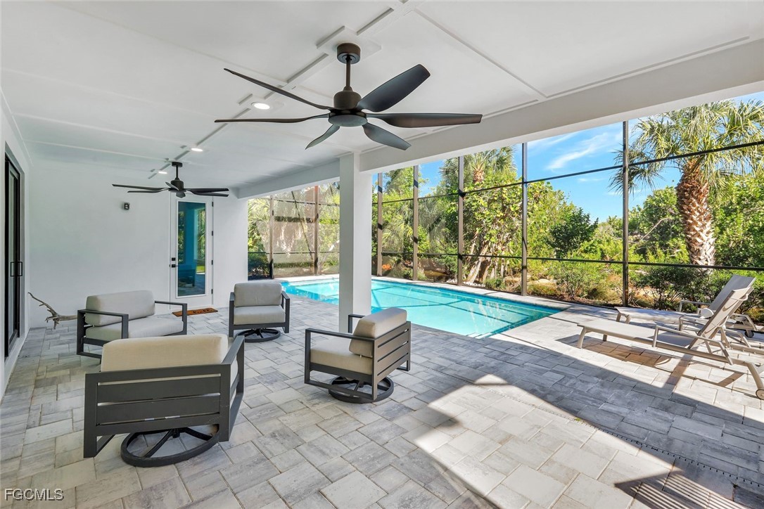 1044 Fish Crow Road Sanibel, FL 33957 - Photo 34 of 36 a living room with patio furniture and a floor to ceiling window