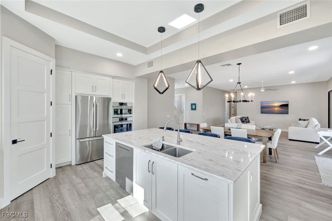 1044 Fish Crow Road Sanibel, FL 33957 - Photo 7 of 36 a kitchen with stainless steel appliances a sink stove and refrigerator
