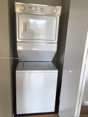 a close view of washer and dryer with wooden floor