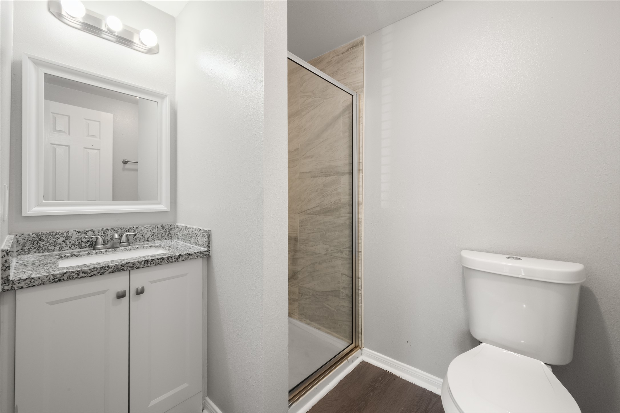 9210 Compton Street Houston, TX 77016 - Photo 4 of 50 Modern bathroom featuring a sleek granite countertop, spacious shower with elegant tile, and bright, contemporary lighting.