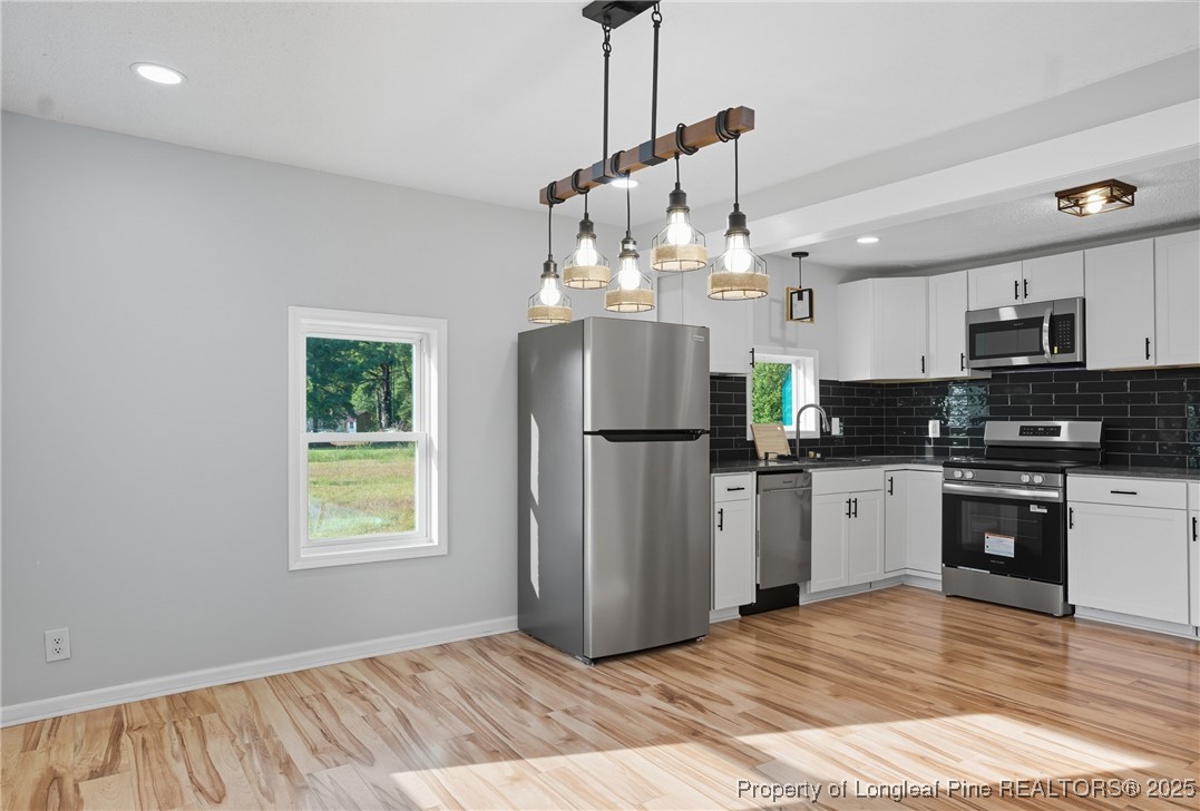 8306 Godwin-Falcon Road Godwin, NC 28344 - Photo 12 of 50 a kitchen with stainless steel appliances granite countertop a refrigerator a sink dishwasher a stove and white cabinets with wooden floor