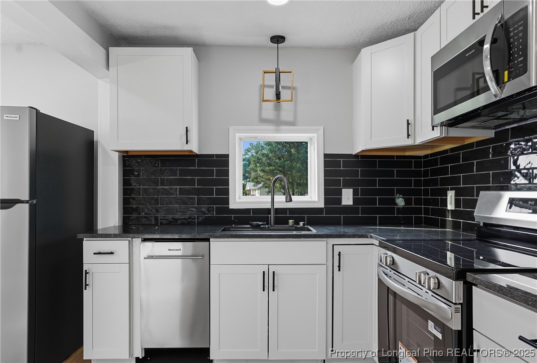 8306 Godwin-Falcon Road Godwin, NC 28344 - Photo 20 of 50 a kitchen with stainless steel appliances a sink stove and microwave