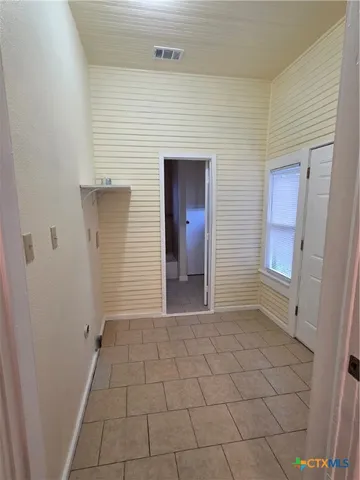 a view of a hallway with wooden cabinets