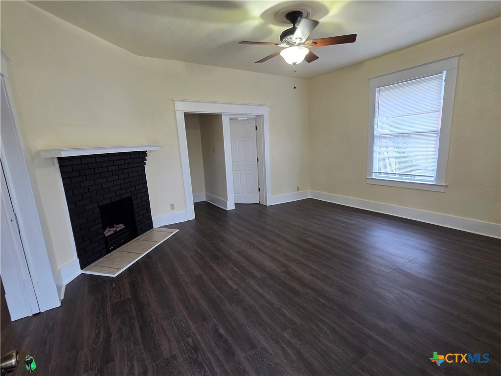 1214 South 11th Street Temple, TX 76504 - Photo 4 of 23 wooden floor in an empty room with a fireplace