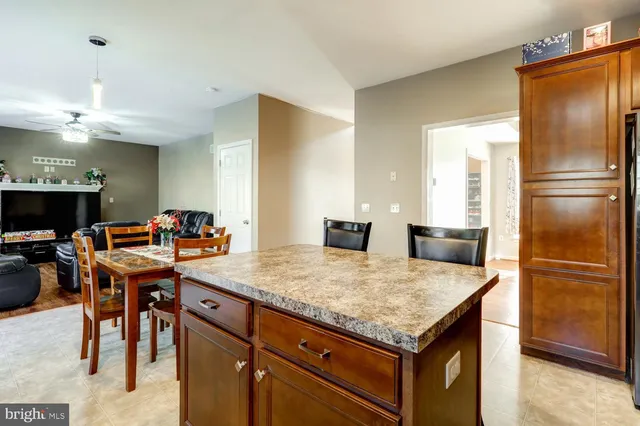 a kitchen with stainless steel appliances granite countertop table chairs and a refrigerator
