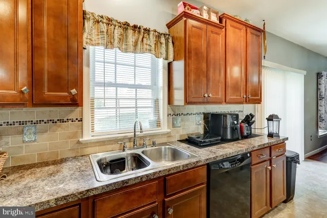 a kitchen with granite countertop a sink a counter space and cabinets