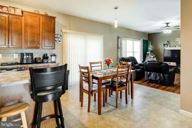 a dining room with furniture a floor to ceiling window and wooden floor
