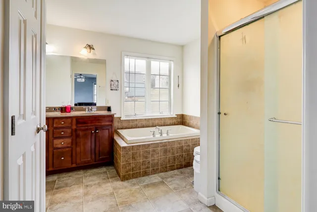 a bathroom with a tub sink and mirror