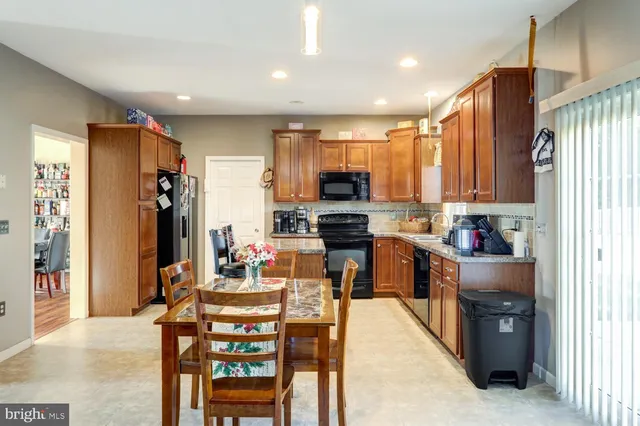 a kitchen with stainless steel appliances kitchen island granite countertop a refrigerator and cabinets