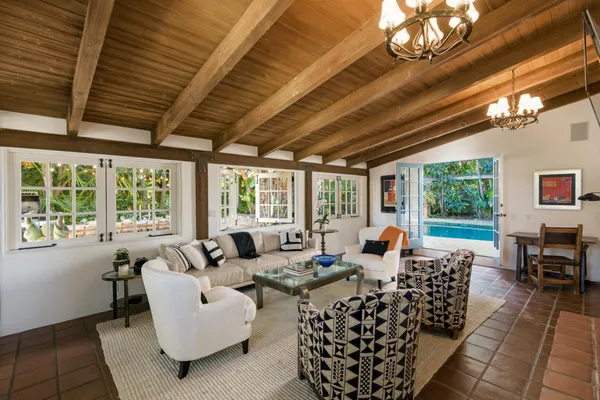 a living room with furniture fireplace and large windows