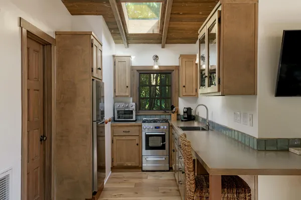 a kitchen with stainless steel appliances granite countertop a refrigerator a stove and a sink with wooden floor