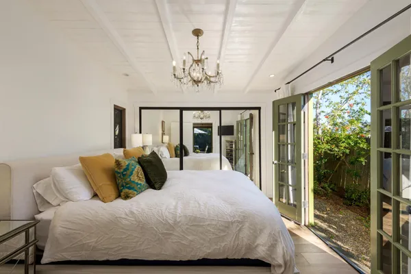 a bedroom with a large bed and a chandelier