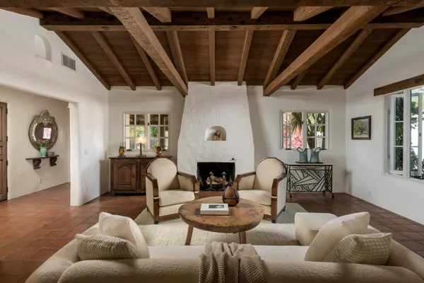 a living room with furniture a fireplace and a chandelier