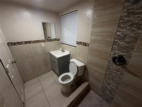 a bathroom with a toilet and a shower