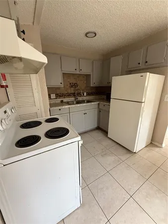 a kitchen with a white stove top oven and white countertops